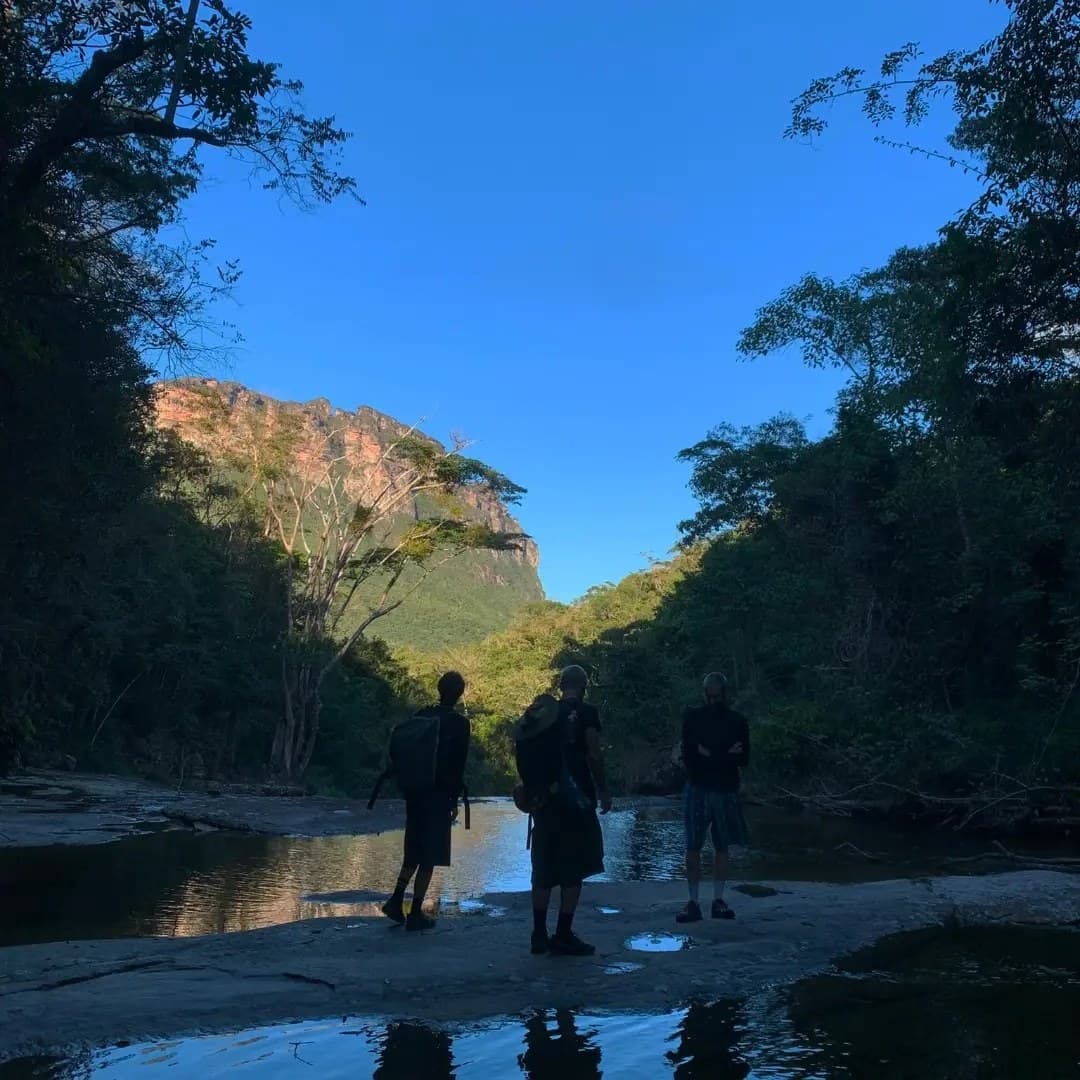Caminantes en silueta en el lecho del río al atardecer